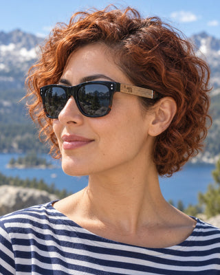 Pyramid Peak polarized sunglasses worn by a woman at a granite overlook above a Sierra lake